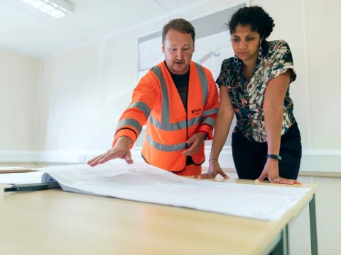 Engineers reviewing blueprints on a table